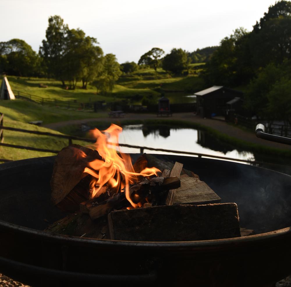 Fire pit beside the fishing lake at Wigwam Holidays Brampton in Cumbria