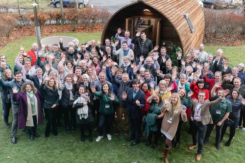All the members of the wigwam network standing outside a cabin at the annual wigwam conference