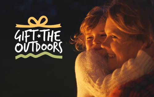 A mother and child cuddling with gift the outdoors text over the top